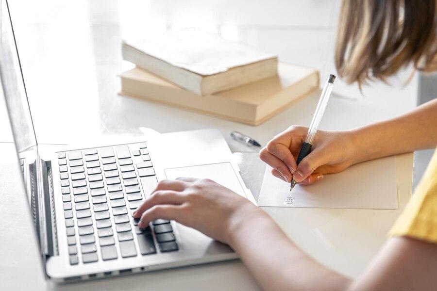 adolescente haciendo los deberes con la computadora portatil